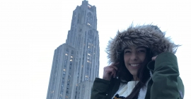 Christen Stefanelli in a winter coat in front of the Cathedral of Learning